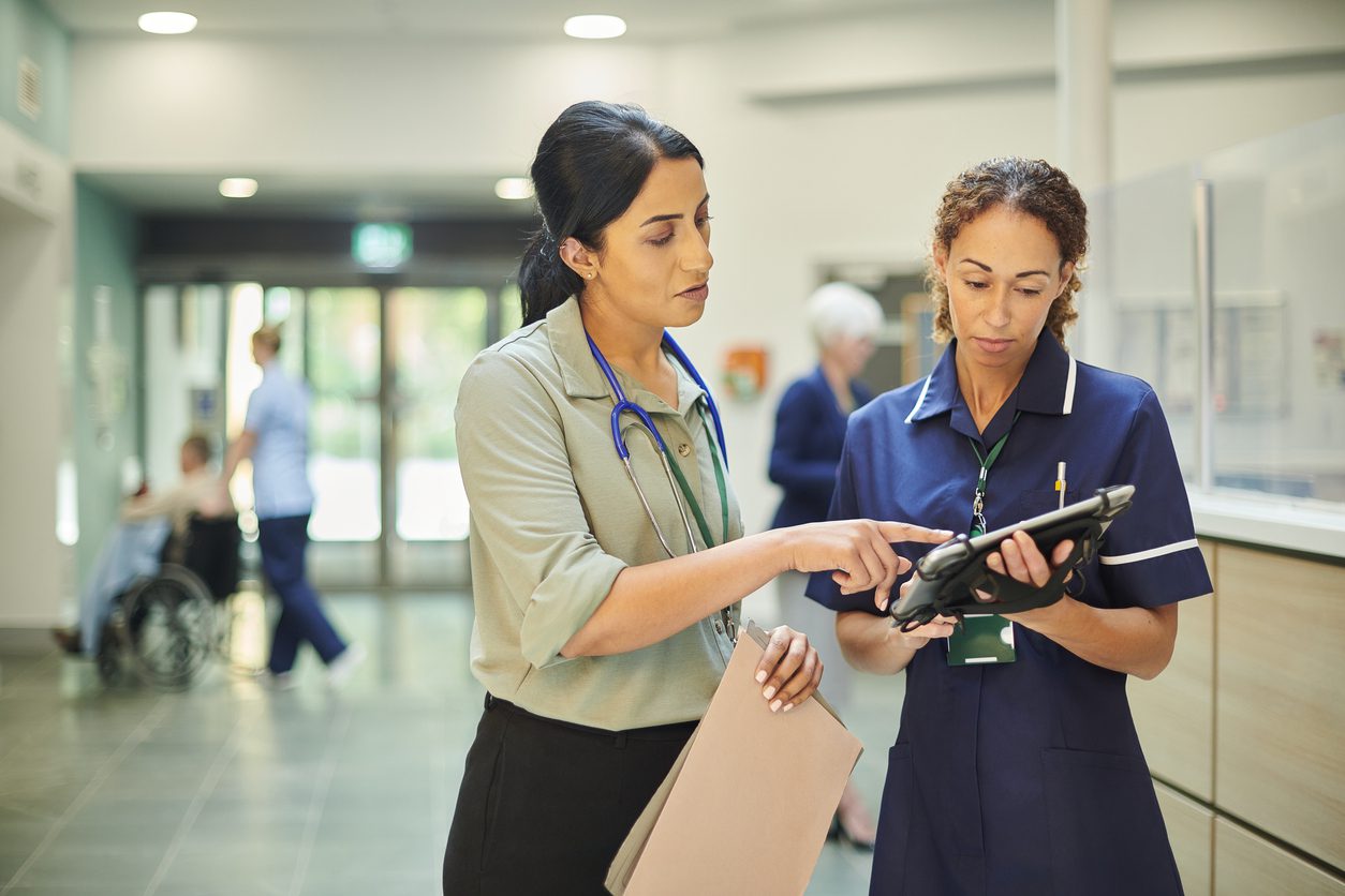 hospital colleagues checking medical records database Crossings Healthcare Solutions - Products and Services